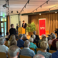 Heimerl spricht an Rednerpult über die Person Rittmann und das Einstehen für Demokratie, davor sitzt das Publikum.